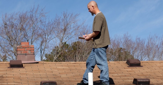 man performing roof inspection